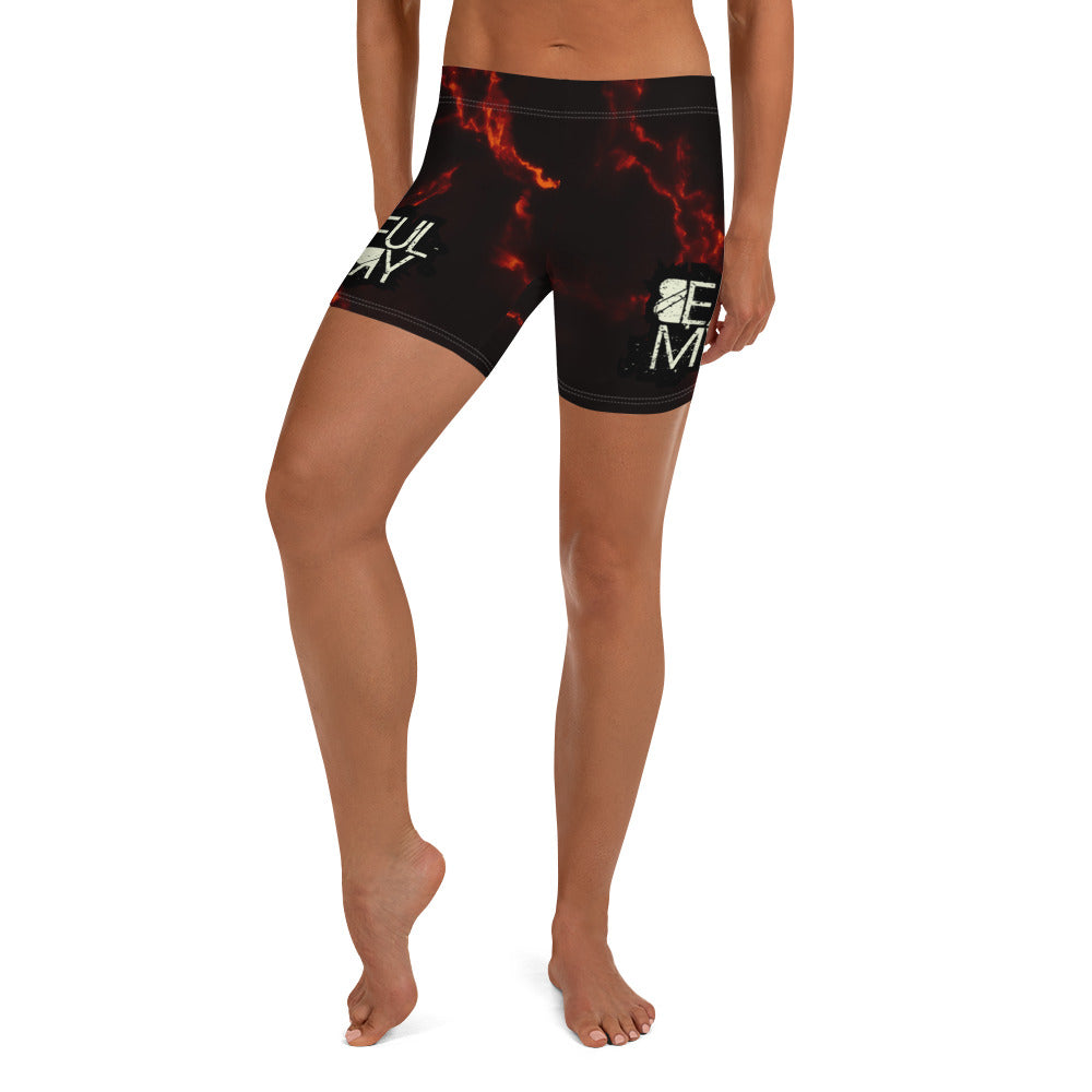 A woman stands confidently in shorts adorned with vibrant flame patterns, showcasing a bold and stylish summer look.