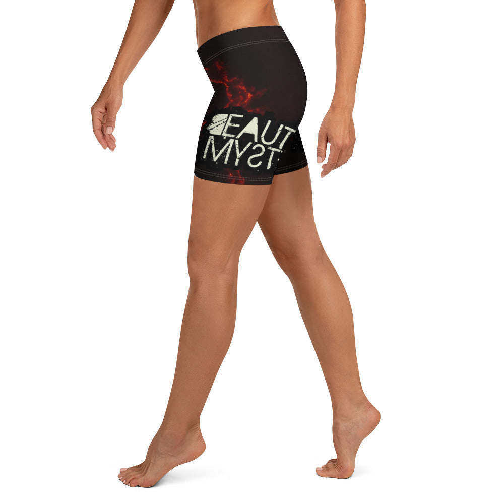 A woman stands confidently in shorts adorned with vibrant flame patterns, showcasing a bold and stylish summer look.