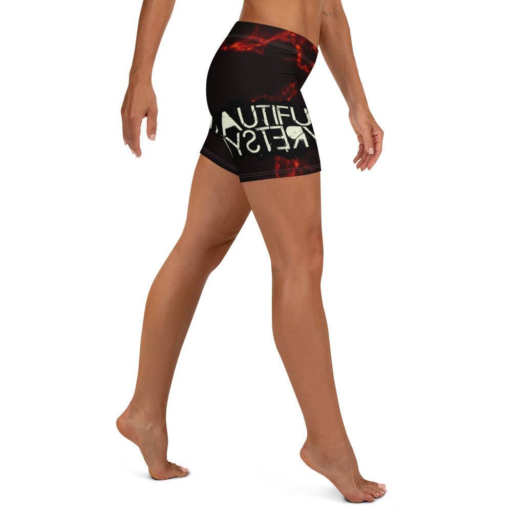 A woman stands confidently in shorts adorned with vibrant flame patterns, showcasing a bold and stylish summer look.