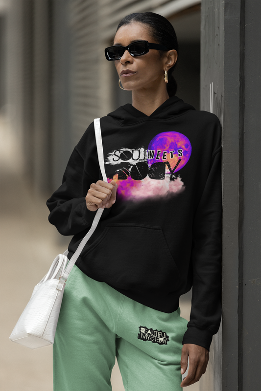 A woman in a hoodie displaying the words "soul rock," standing confidently with a neutral background.