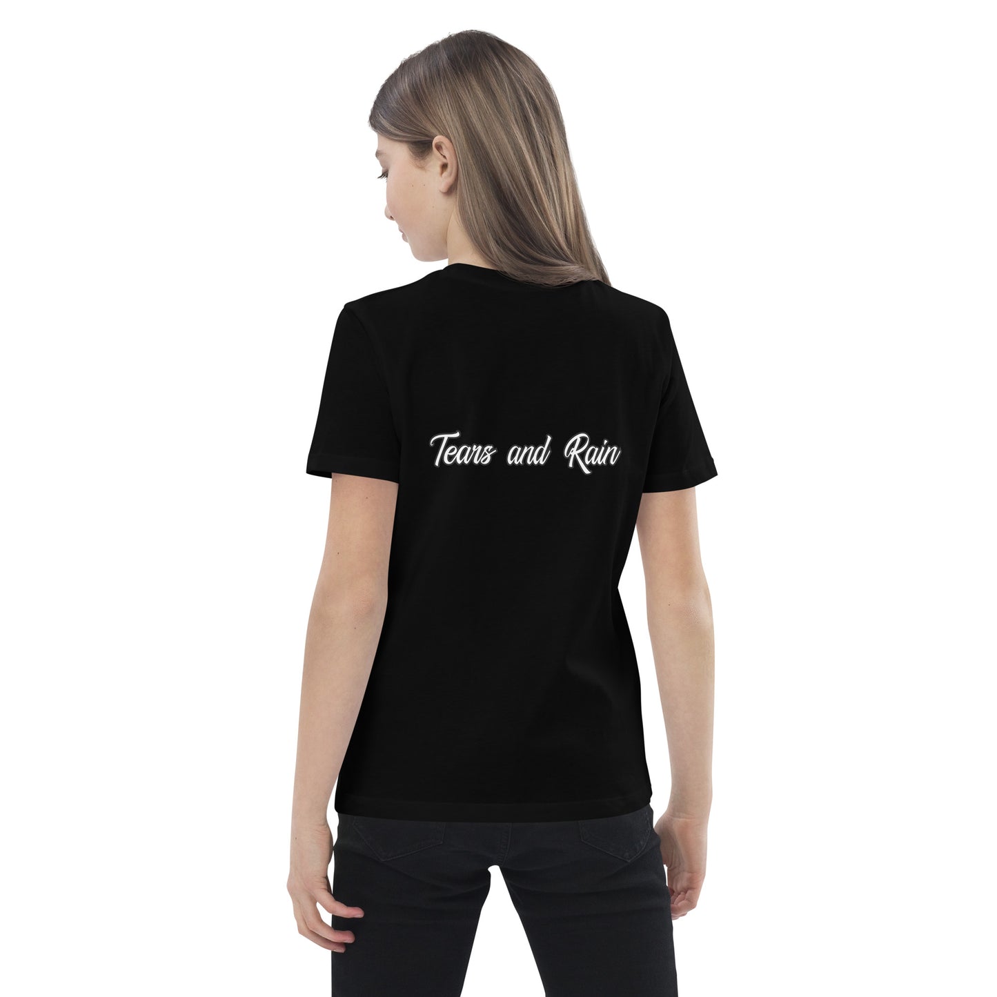  A girl in a t-shirt reading "my family is the greatest gift," smiling and standing in a bright outdoor setting.