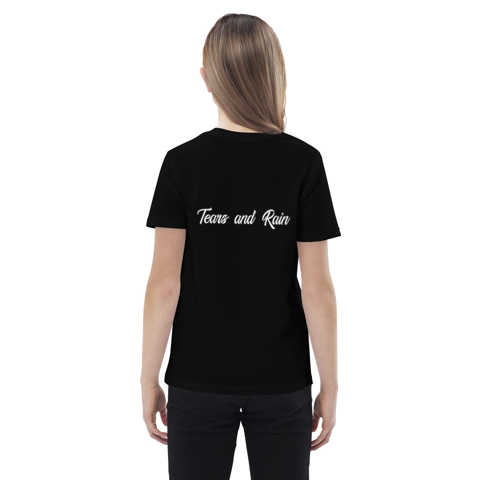  A girl in a t-shirt reading "my family is the greatest gift," smiling and standing in a bright outdoor setting.